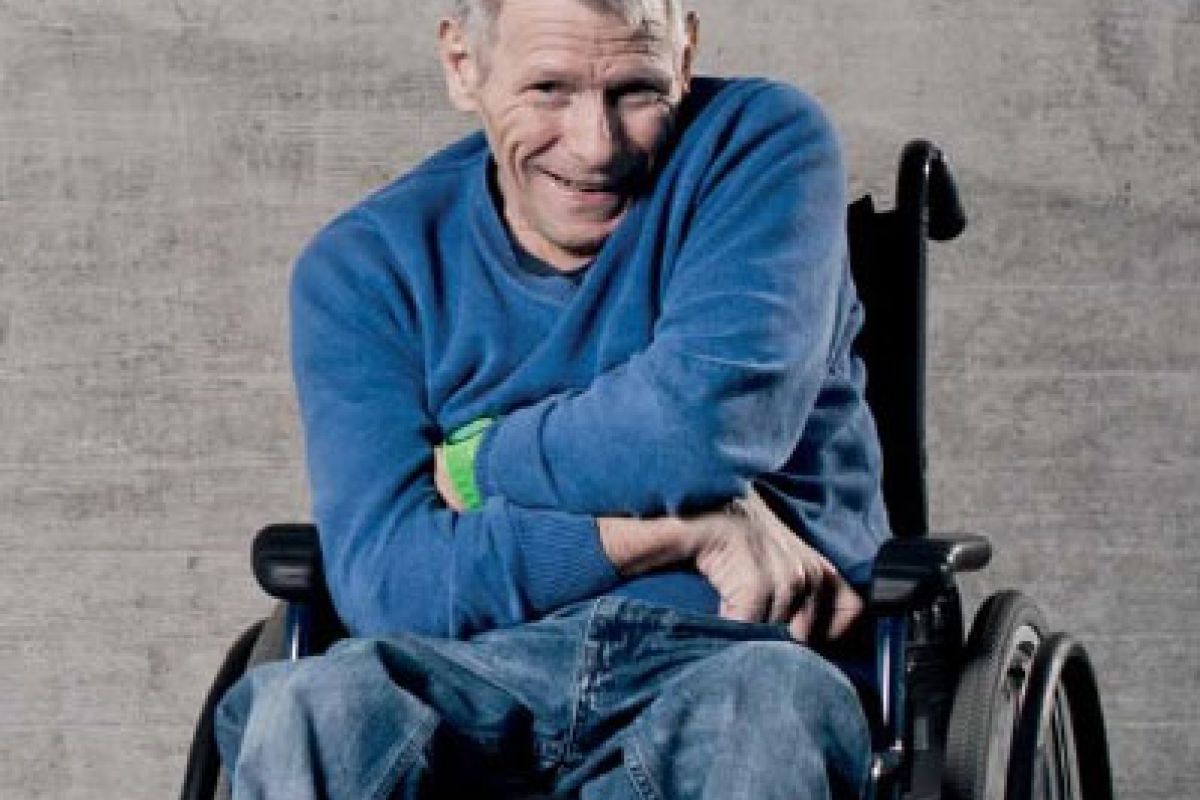 Mann im Rollstuhl lacht fröhlich